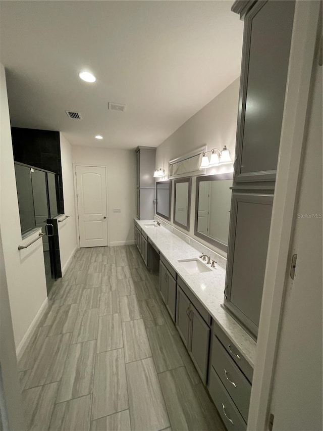 bathroom featuring vanity and a shower with door