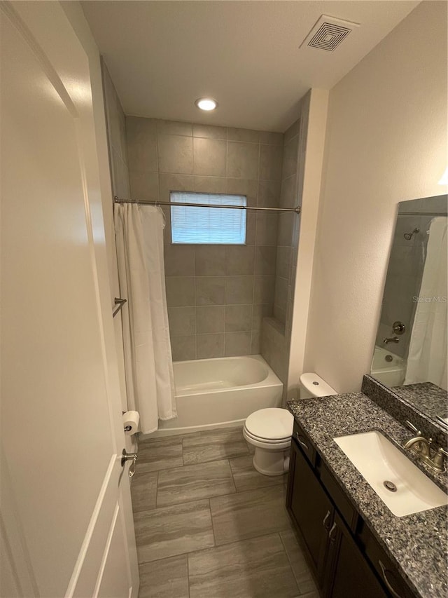 full bathroom featuring shower / bath combo, vanity, and toilet