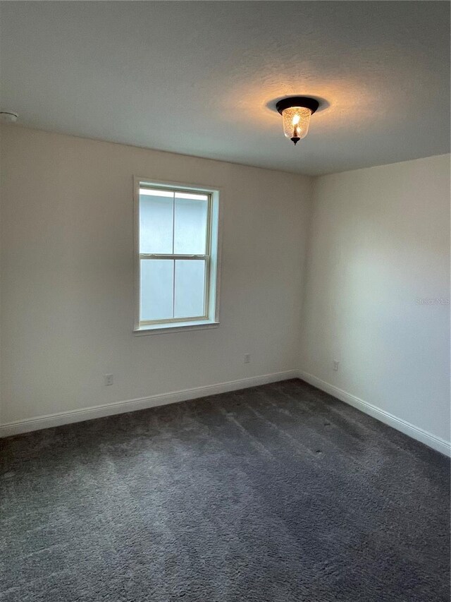 empty room with dark colored carpet