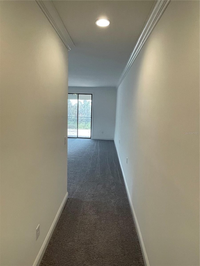 hallway featuring dark colored carpet and ornamental molding