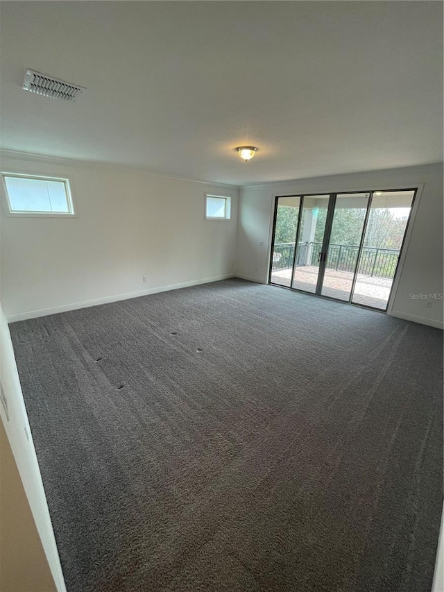 empty room featuring a healthy amount of sunlight and dark carpet