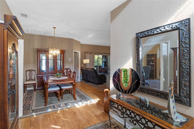 dining space featuring hardwood / wood-style floors and an inviting chandelier