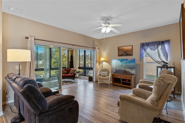 living room with light hardwood / wood-style floors and ceiling fan