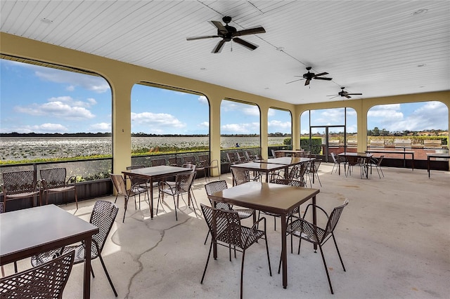 view of patio featuring a water view and ceiling fan