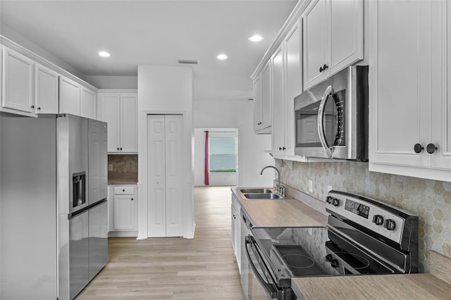 4112 Aberdeen Ln, Lake Wales, FL 33859 - kitchen with stainless steel appliances, backsplash, recessed lighting, light wood-type flooring, and white cabinets