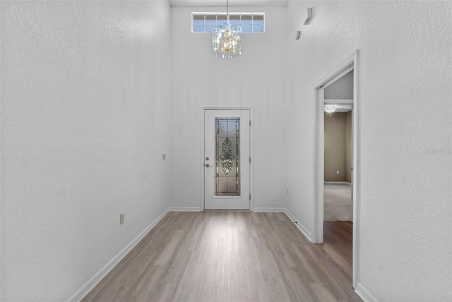 4112 Aberdeen Ln, Lake Wales, FL 33859 - entryway featuring wood finished floors, a chandelier, a towering ceiling, and a textured wall
