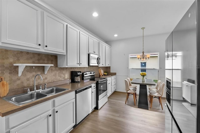4112 Aberdeen Ln, Lake Wales, FL 33859 - kitchen featuring appliances with stainless steel finishes, backsplash, white cabinets, decorative light fixtures, and recessed lighting