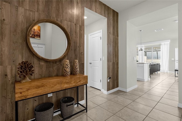 hall with light tile patterned floors and wooden walls