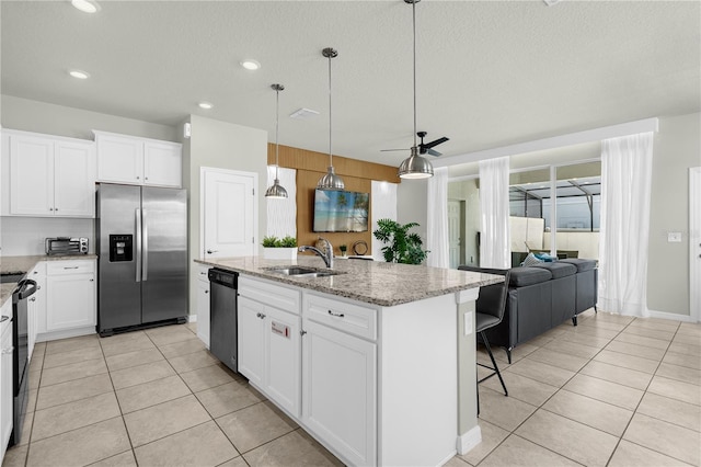 kitchen featuring a center island with sink, white cabinets, sink, decorative light fixtures, and stainless steel appliances