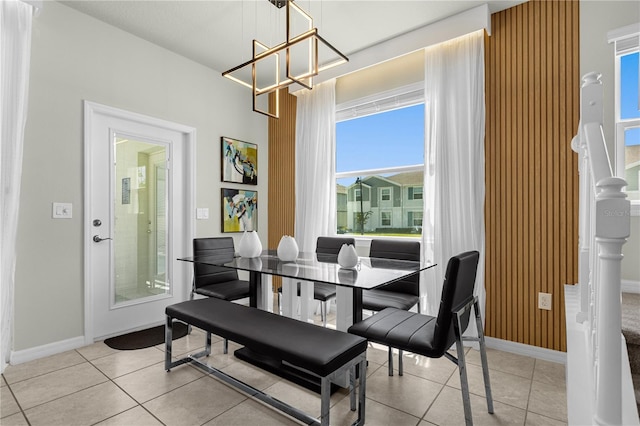 dining space featuring light tile patterned floors and a notable chandelier