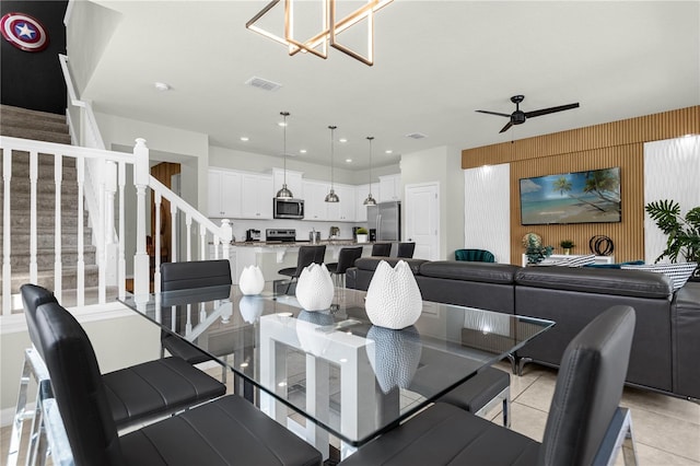 tiled dining room with ceiling fan with notable chandelier