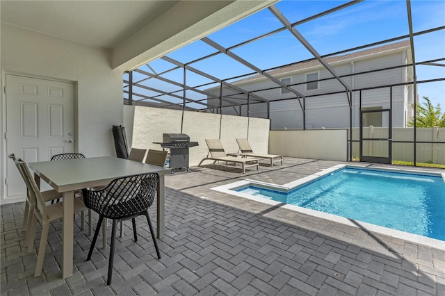 view of swimming pool featuring a lanai, a patio area, and a grill