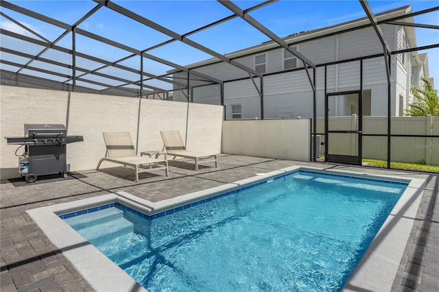 view of pool featuring a lanai, a patio area, and grilling area