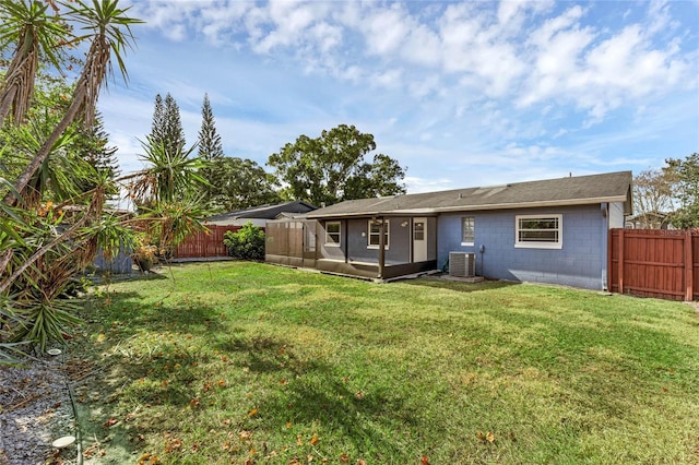 back of house with a yard and central AC unit