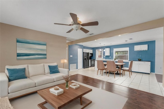 living room with ceiling fan and light hardwood / wood-style floors