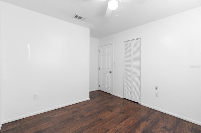 unfurnished bedroom with dark hardwood / wood-style floors, ceiling fan, and a closet