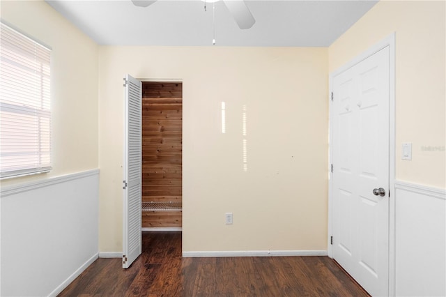 unfurnished bedroom with dark hardwood / wood-style flooring, a closet, and ceiling fan