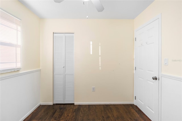 unfurnished bedroom with dark hardwood / wood-style floors, ceiling fan, and a closet