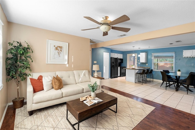 living room with ceiling fan and light wood-type flooring