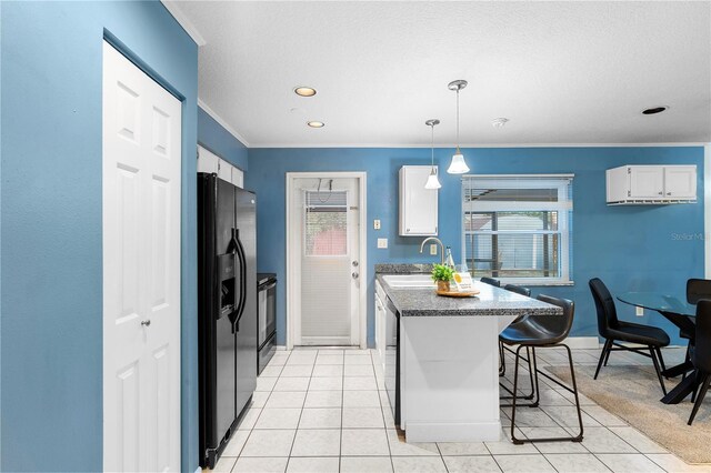 kitchen with hanging light fixtures, white cabinetry, sink, and black fridge with ice dispenser