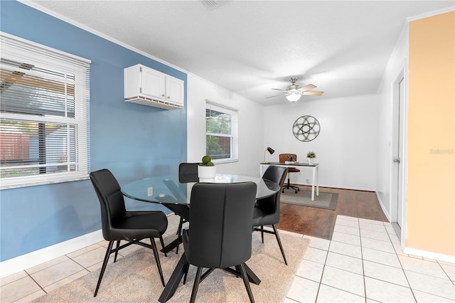 tiled dining space featuring crown molding, ceiling fan, and a textured ceiling