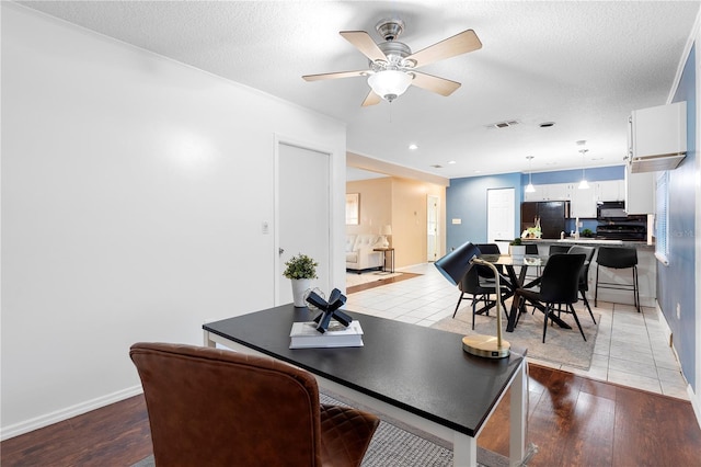 dining space featuring ceiling fan, light hardwood / wood-style flooring, and a textured ceiling