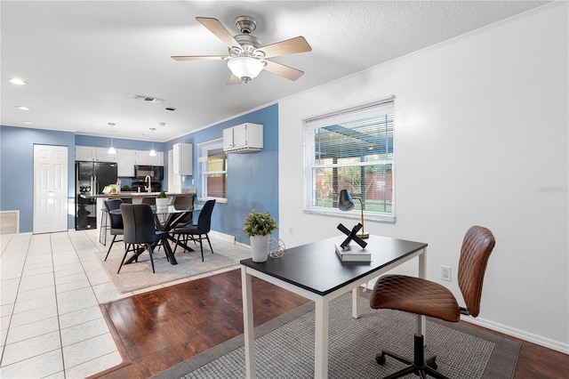 dining space with ornamental molding, light tile patterned flooring, ceiling fan, and a textured ceiling