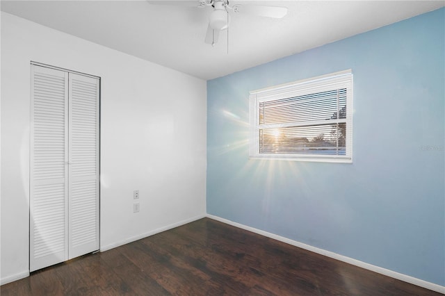 unfurnished bedroom featuring ceiling fan, dark hardwood / wood-style flooring, and a closet