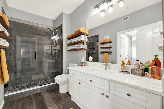 bathroom featuring toilet, vanity, an enclosed shower, and hardwood / wood-style flooring