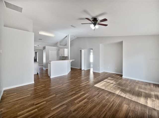 unfurnished living room featuring dark hardwood / wood-style floors, ceiling fan, and vaulted ceiling