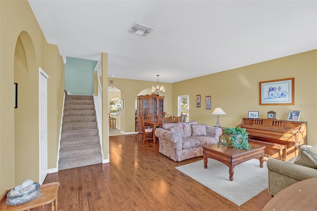 living room with a chandelier, hardwood / wood-style floors, and a textured ceiling