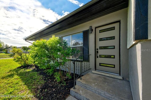 doorway to property featuring a lawn