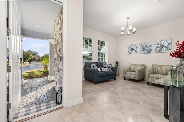 tiled living room featuring a healthy amount of sunlight and a chandelier