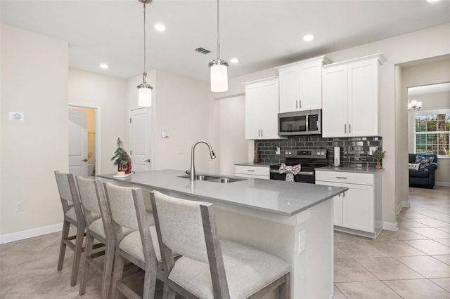 kitchen featuring white cabinetry, sink, hanging light fixtures, a kitchen island with sink, and appliances with stainless steel finishes