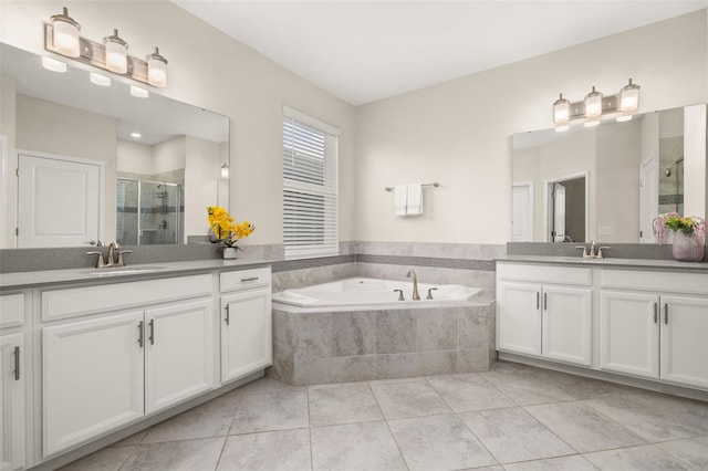 bathroom featuring plus walk in shower, vanity, and tile patterned flooring