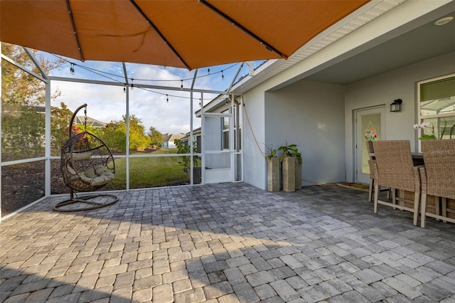 view of patio featuring glass enclosure