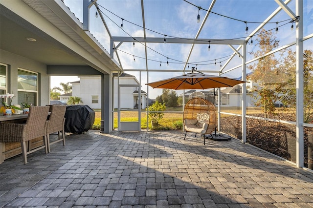 view of patio featuring glass enclosure and area for grilling