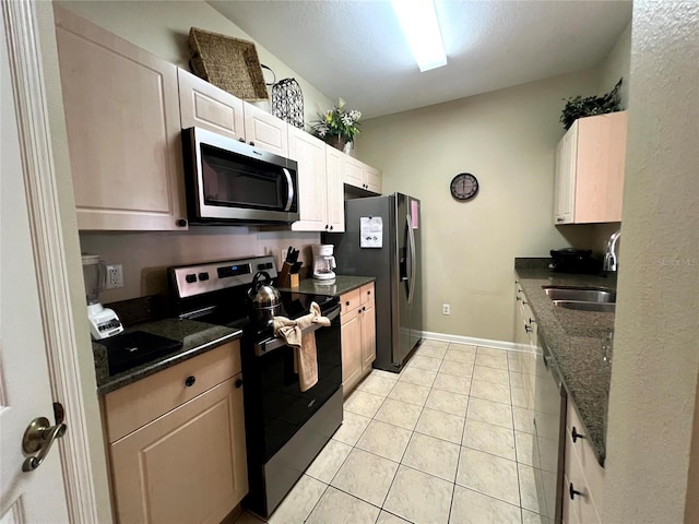 kitchen with light tile patterned flooring, stainless steel appliances, white cabinetry, and sink