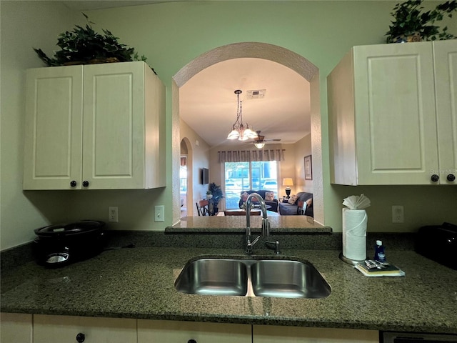 kitchen featuring ceiling fan with notable chandelier, white cabinetry, sink, and hanging light fixtures