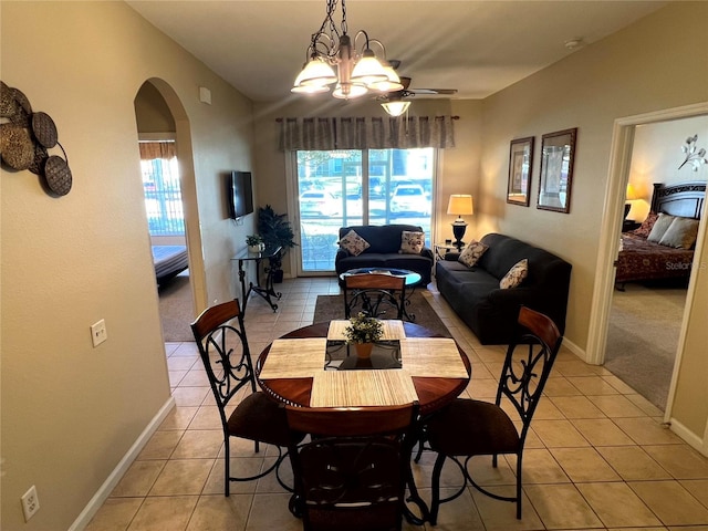 dining area featuring light tile patterned floors and ceiling fan with notable chandelier