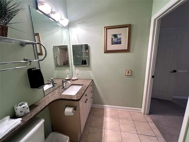 bathroom with tile patterned flooring, vanity, and toilet