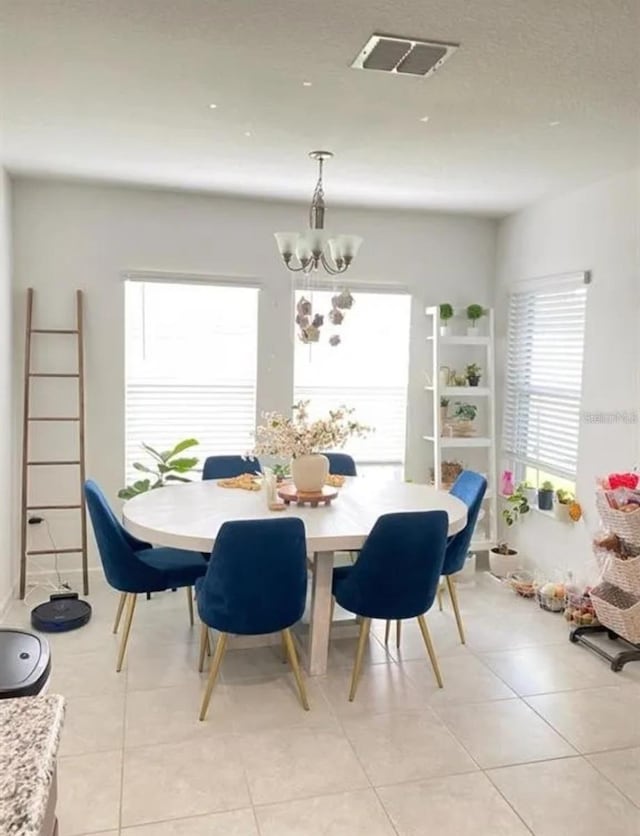 dining space featuring light tile patterned floors and a chandelier