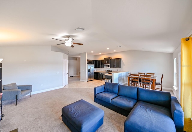 living room featuring light colored carpet, vaulted ceiling, and ceiling fan