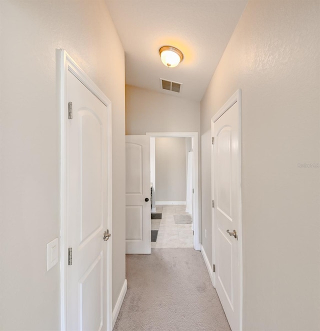 corridor featuring light carpet and lofted ceiling