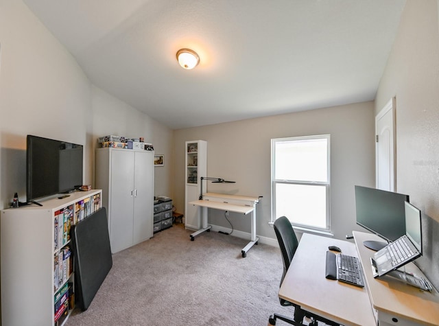 carpeted office featuring lofted ceiling