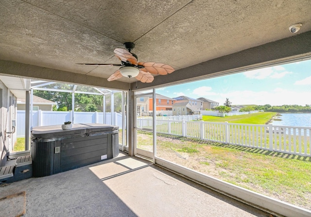 sunroom / solarium featuring a water view, plenty of natural light, and ceiling fan