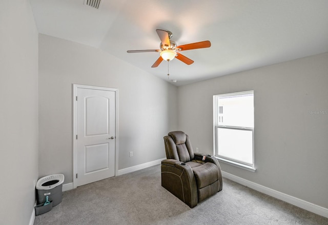 living area with ceiling fan, light colored carpet, and vaulted ceiling