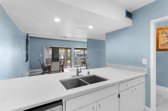 kitchen with white cabinets, white dishwasher, and sink