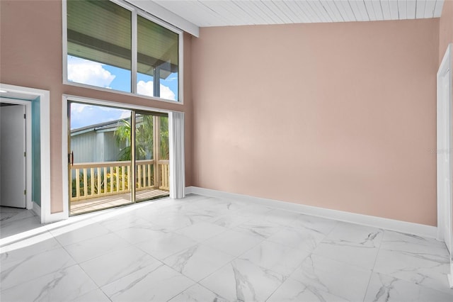 empty room with high vaulted ceiling and wood ceiling