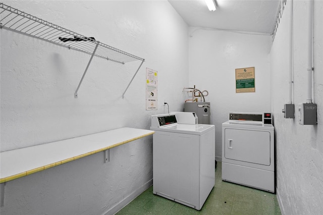 clothes washing area featuring electric water heater and independent washer and dryer